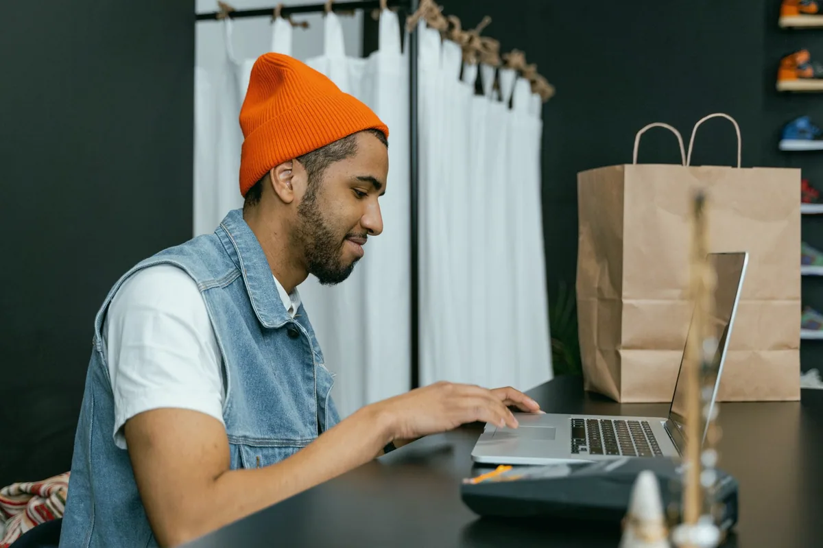 Dizüstü bilgisayarda e-ticaret mağaza paneli üzerinde çalışan kişi