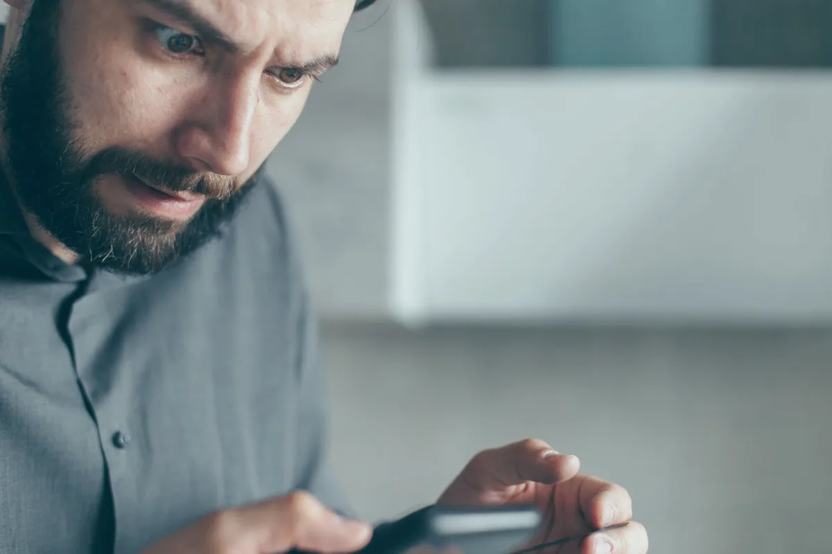 Telefon ekranında sipariş bildirimi kontrol eden satıcı