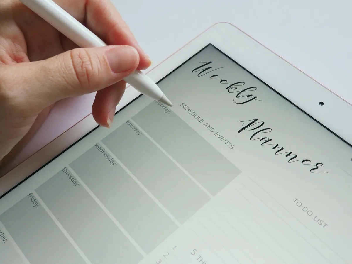 Tablette dijital planlayıcı kullanan kişi