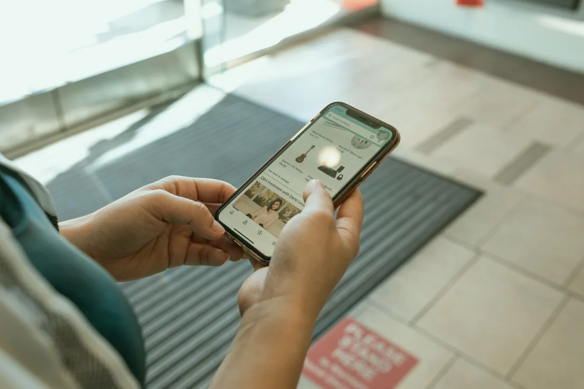 Telefonda çevrim içi mağaza sayfasına bakan kişi
