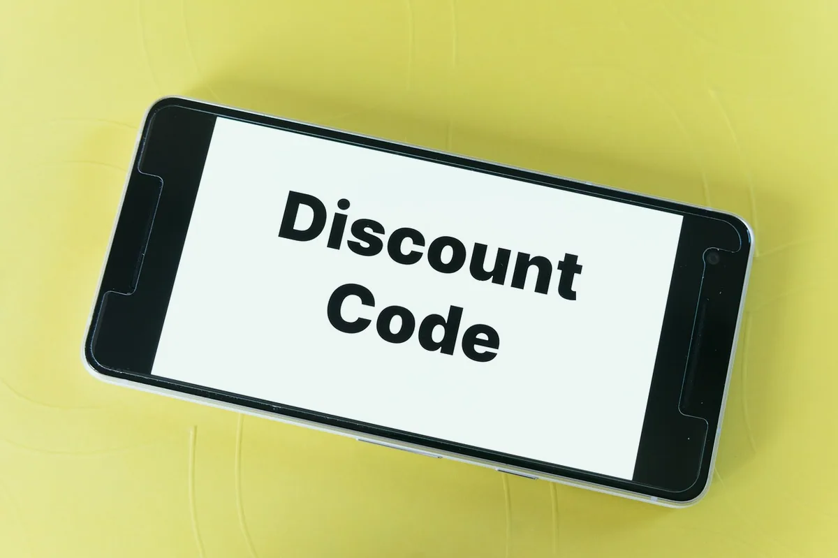 Telefon ekranında indirim kodu girilen online alışveriş sepeti
