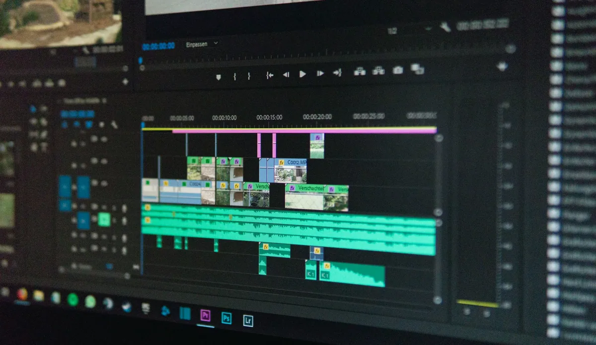 Bilgisayarda zaman çizelgesi üzerinde video kurgulayan kişi