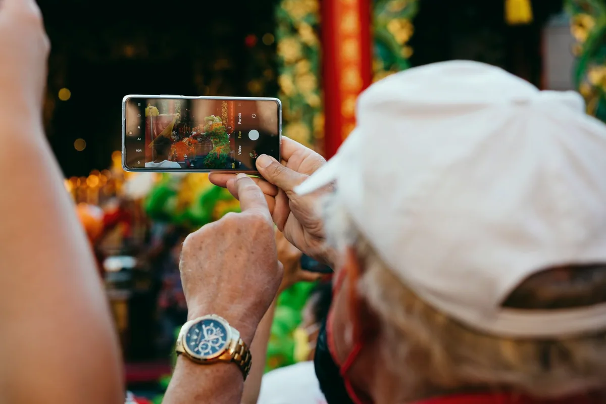 Telefonda dikey formatta kısa video izleyen kişi