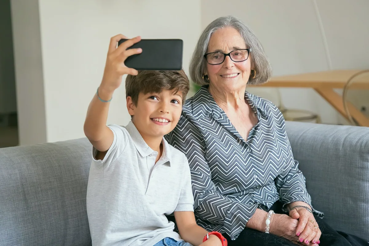 Telefonda aile fotoğraflarına bakan yaşlı kadın