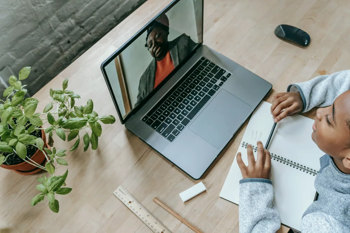 Dizüstü bilgisayarla online ders veren öğretmen