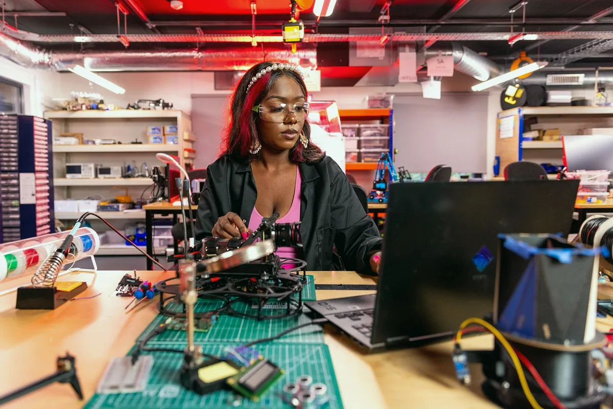 Laboratuvarda robot kol üzerinde çalışan mühendislik öğrencileri