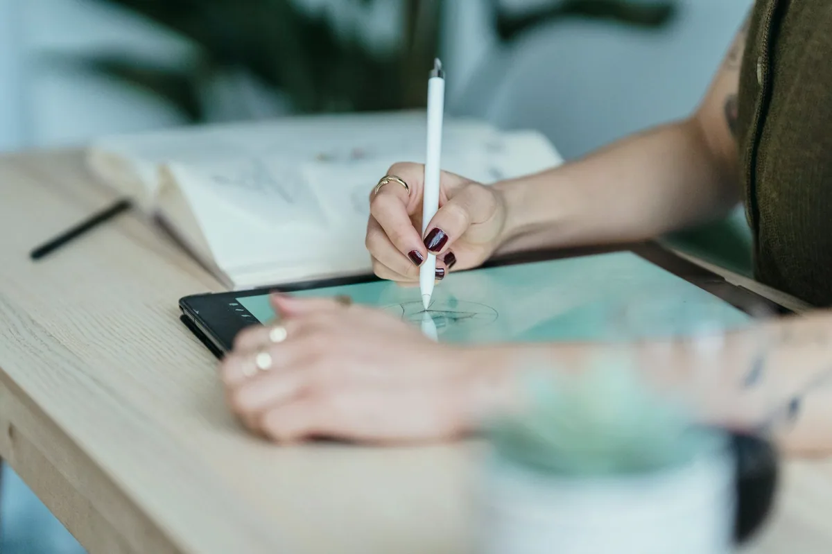 Tablet üzerinde logo eskizi çizen tasarımcı