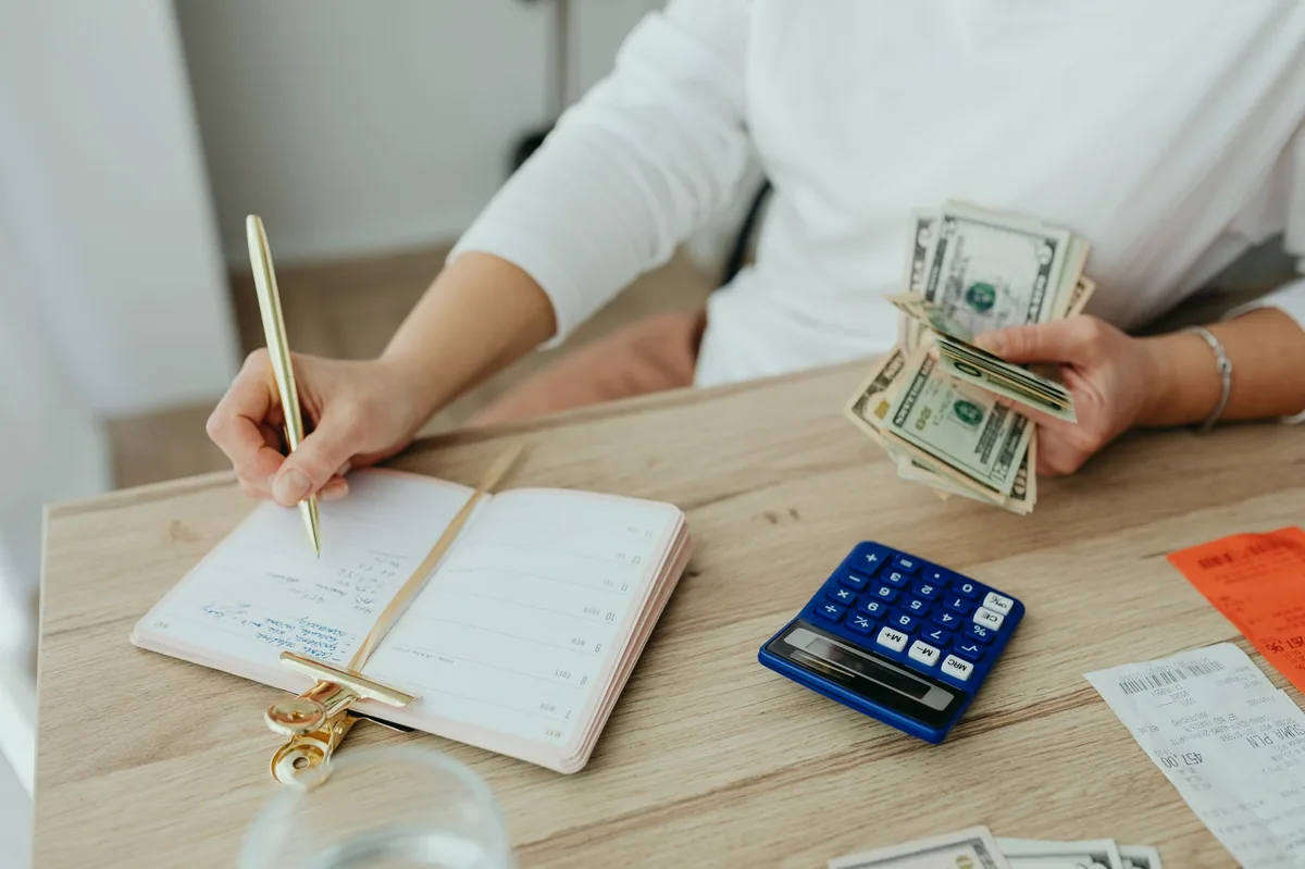 Defterde yazılı aylık gider listesi ve kalem