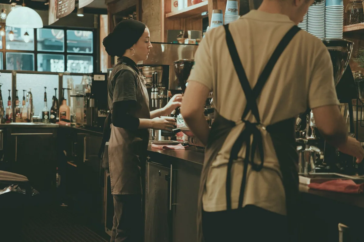Küçük bir kafenin tezgâhında çalışan barista
