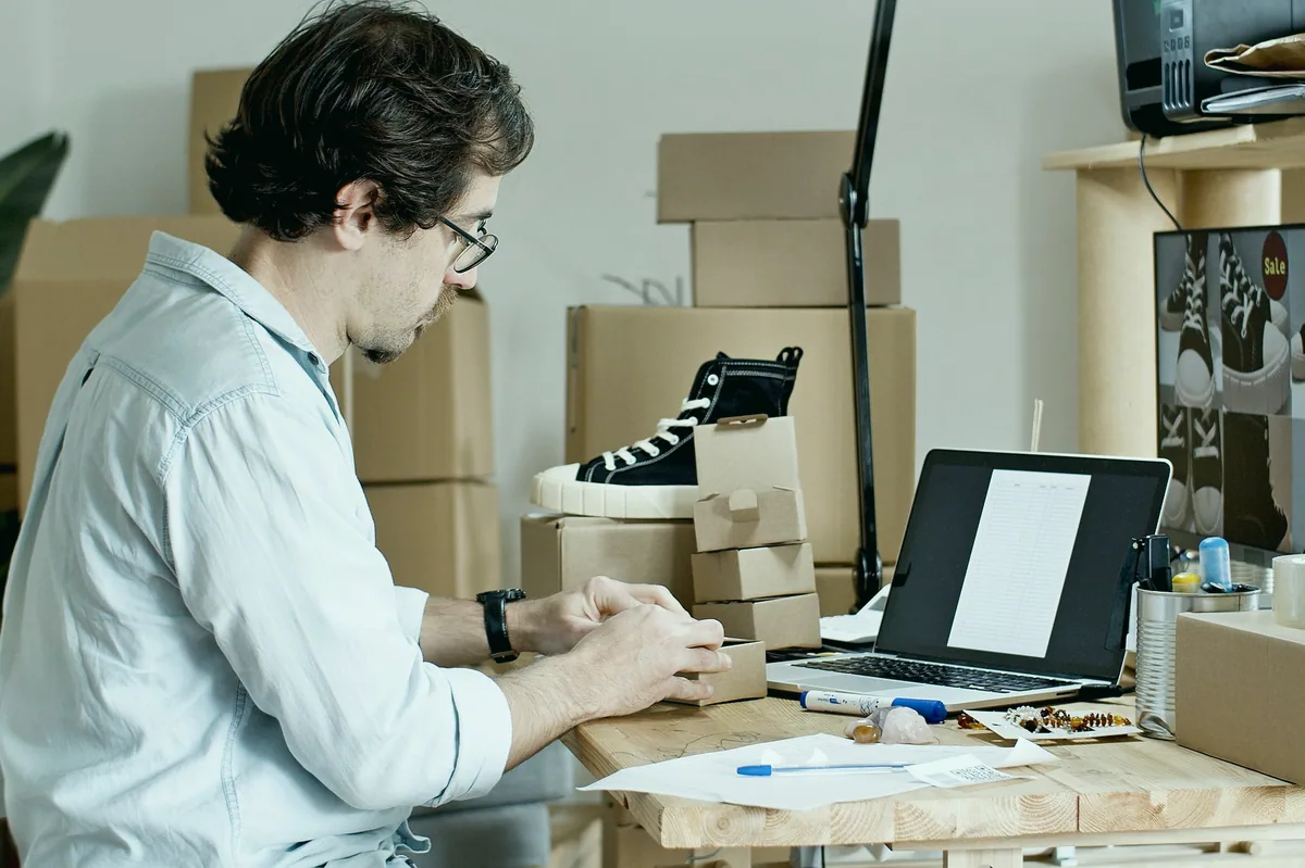 Kargo kutularını paketleyen e-ticaret satıcısı
