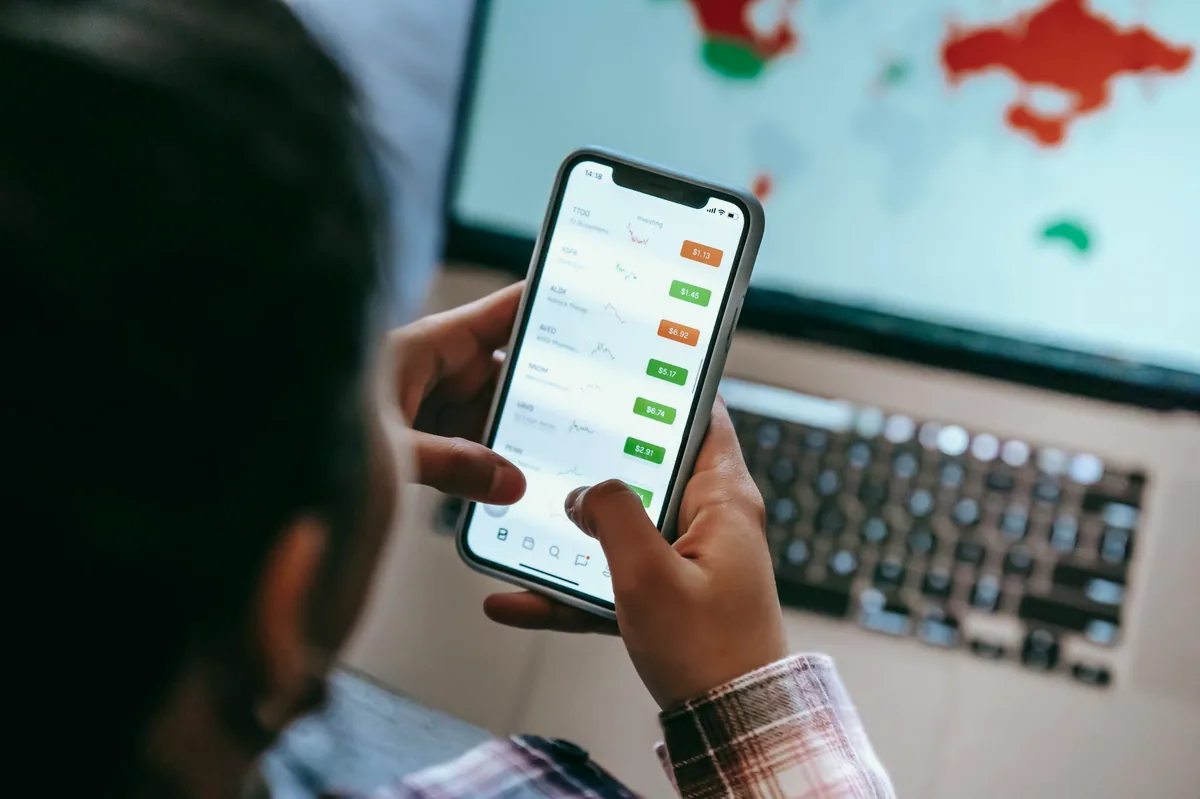 Akıllı telefonda borsa uygulaması ekranına bakan yatırımcı