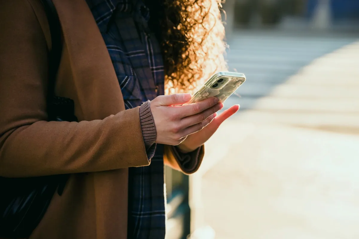 Telefonda Instagram profil istatistiklerine bakan kadın