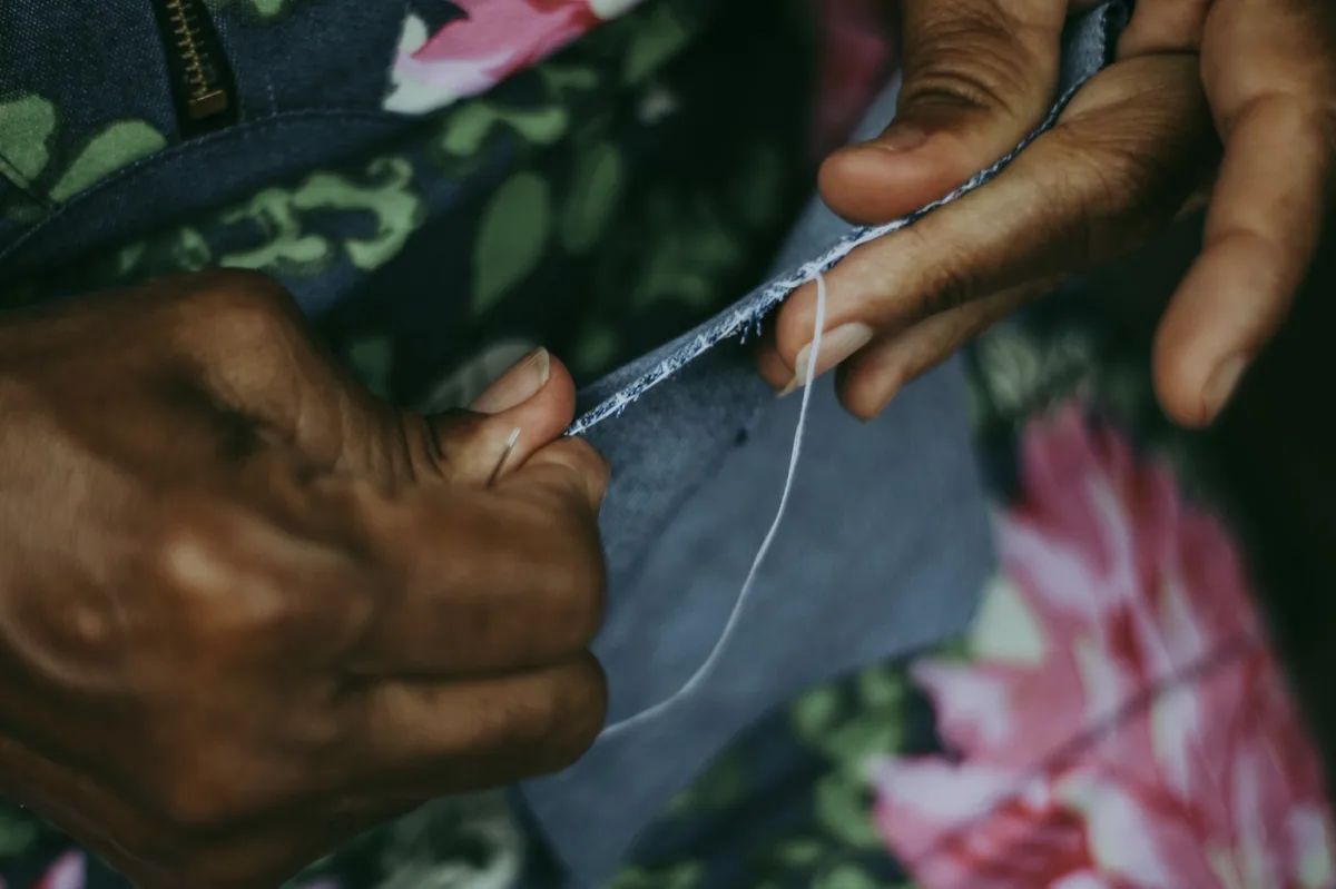 Evde dikiş makinesiyle tadilat yapan kadın