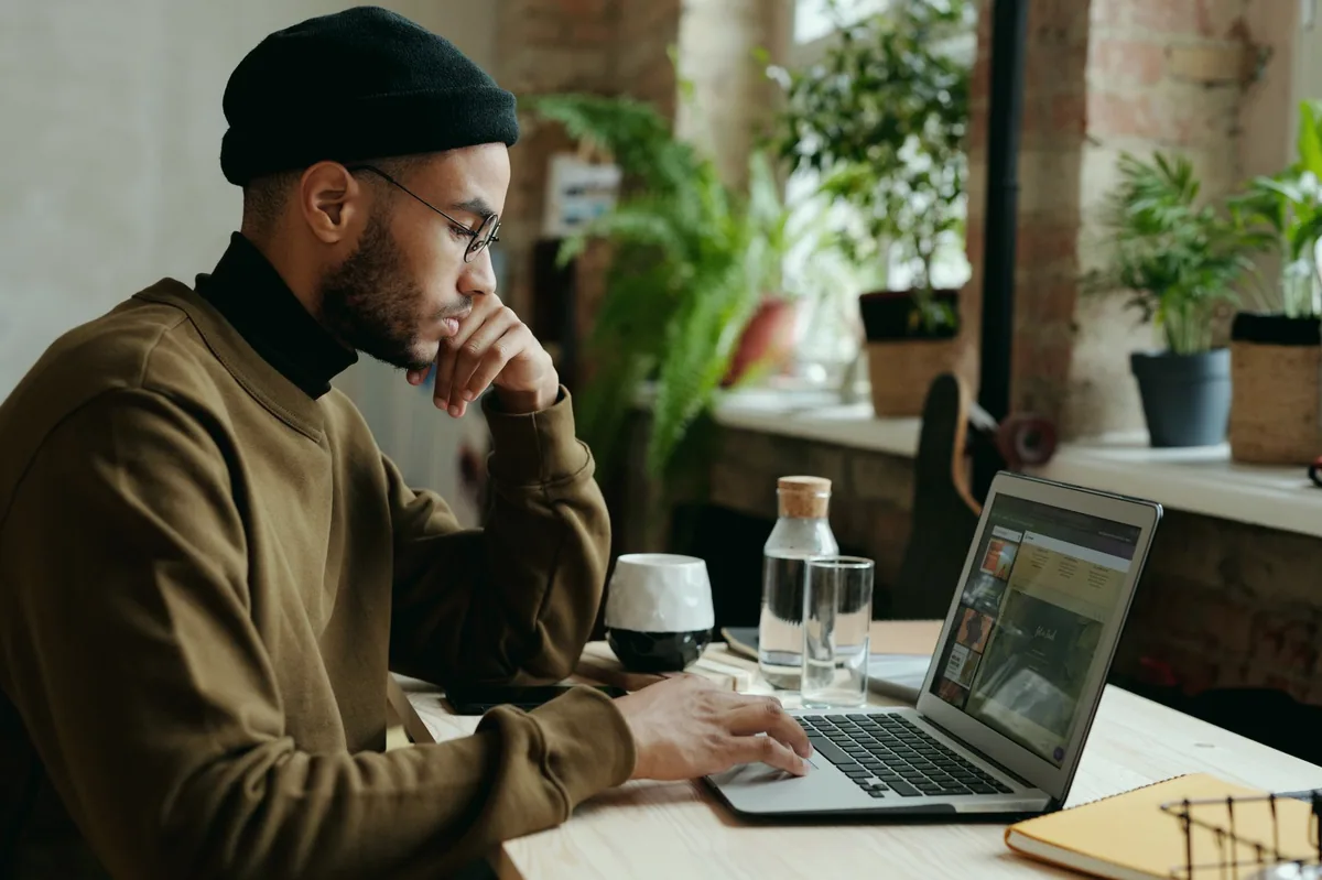 Evdeki çalışma masasında dizüstü bilgisayarla çalışan bir freelancer