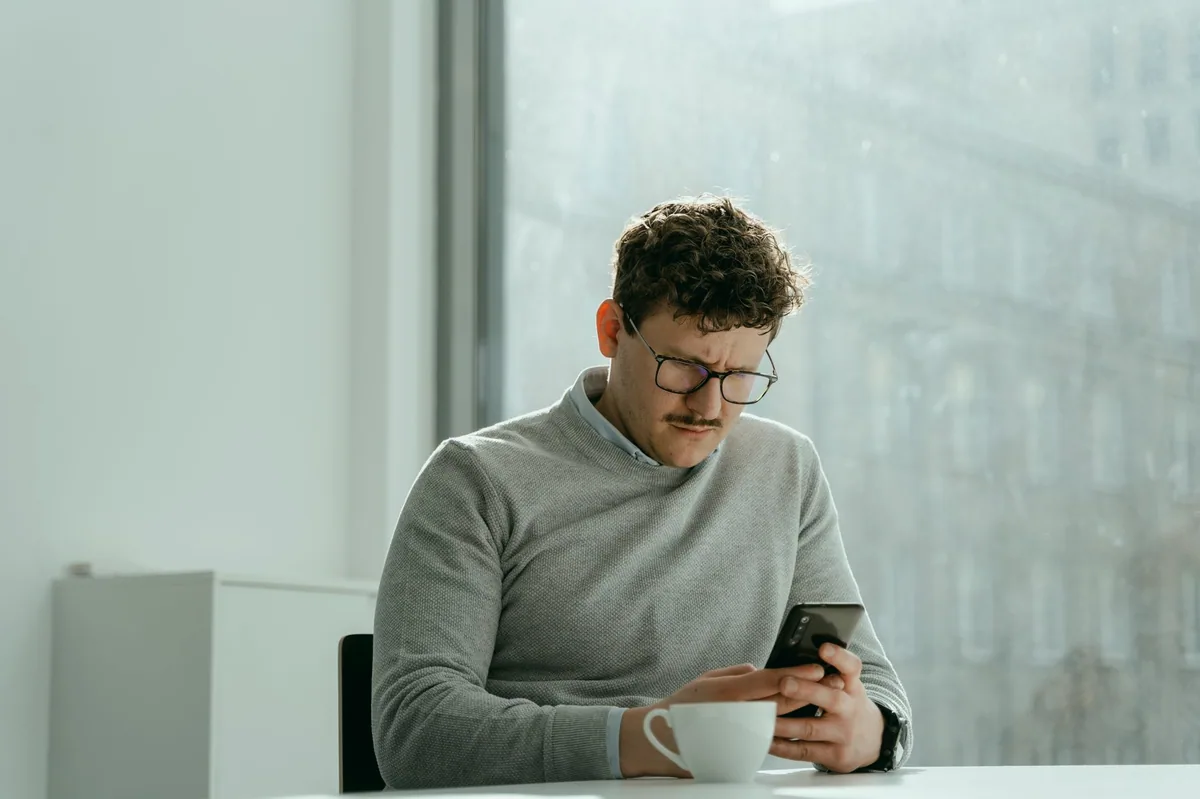 Telefonunda şüpheli bir mesajı inceleyen kişi