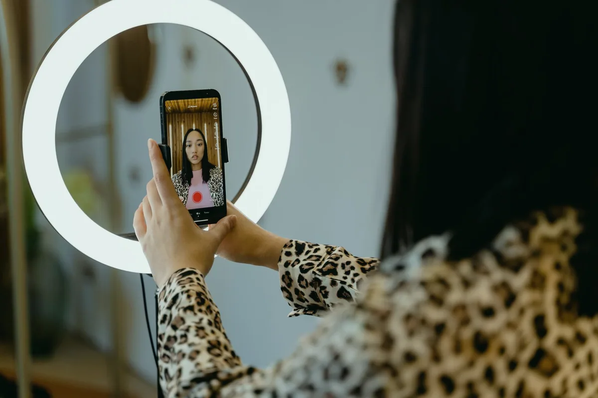 Telefonla canlı yayın yapan genç kadın ve halka ışık