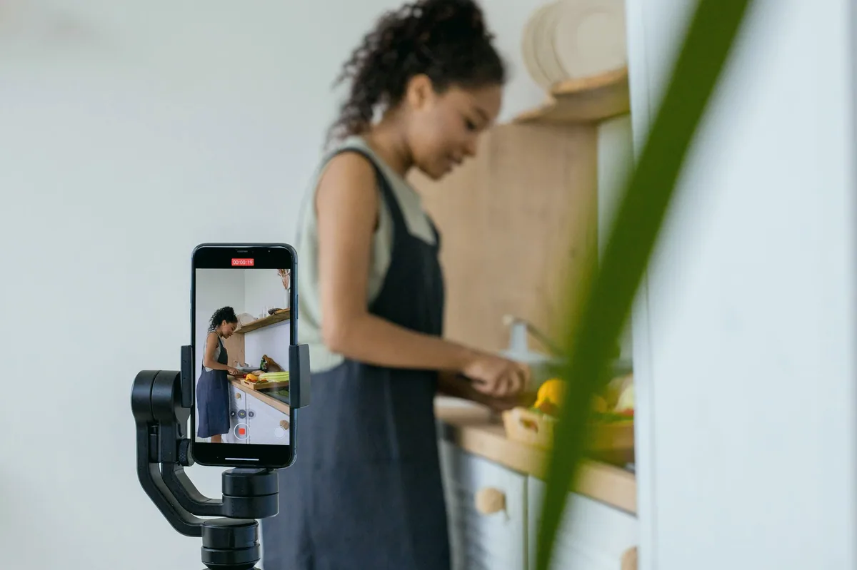 Mutfakta telefonla yemek videosu çeken kadın